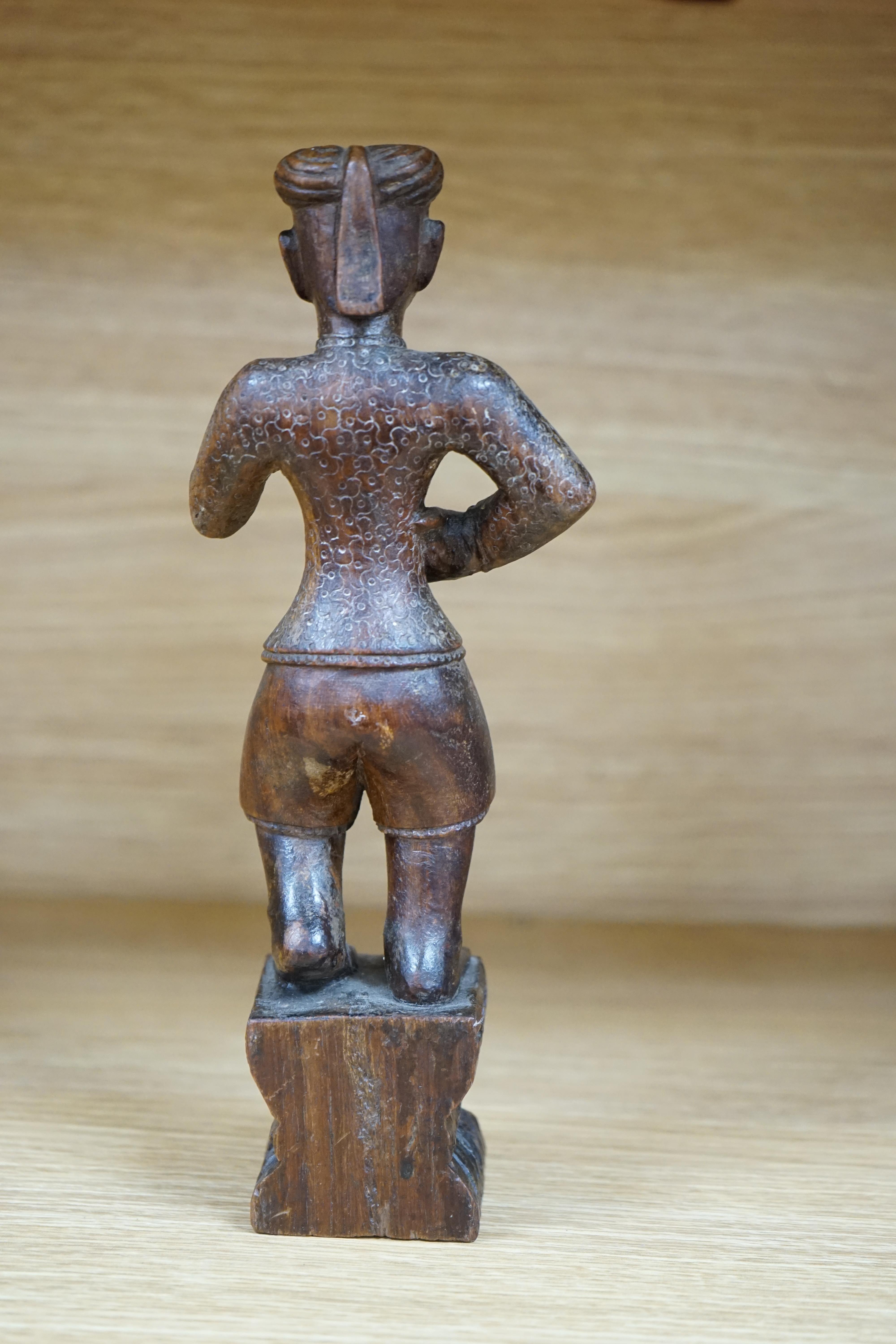 A 19th century Indian carved wood figure of a man, 23cm high. Condition - poor to fair, one arm missing